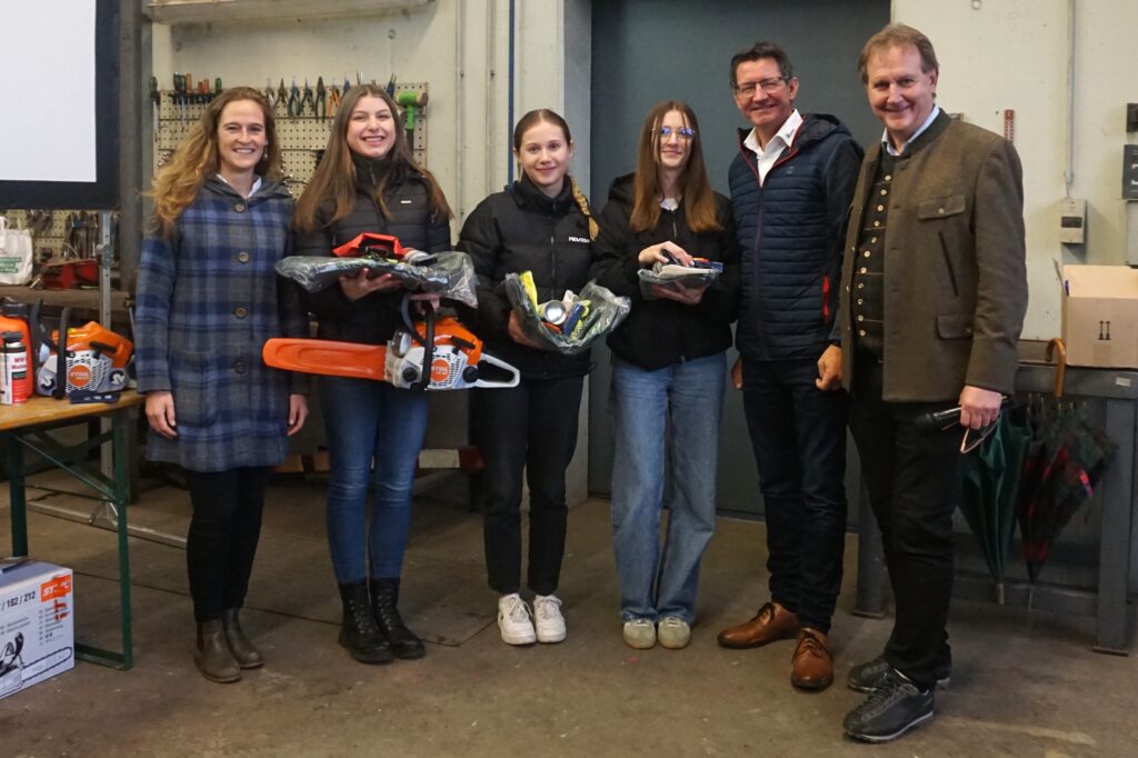 Es stehen mehrere Personen aufgereiht und die Mädels in der Mitte halten Preise.