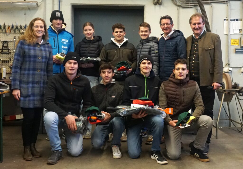 Es stehen mehrere Personen aufgereiht und die Jungs und Mädls in der Mitte halten Preise.