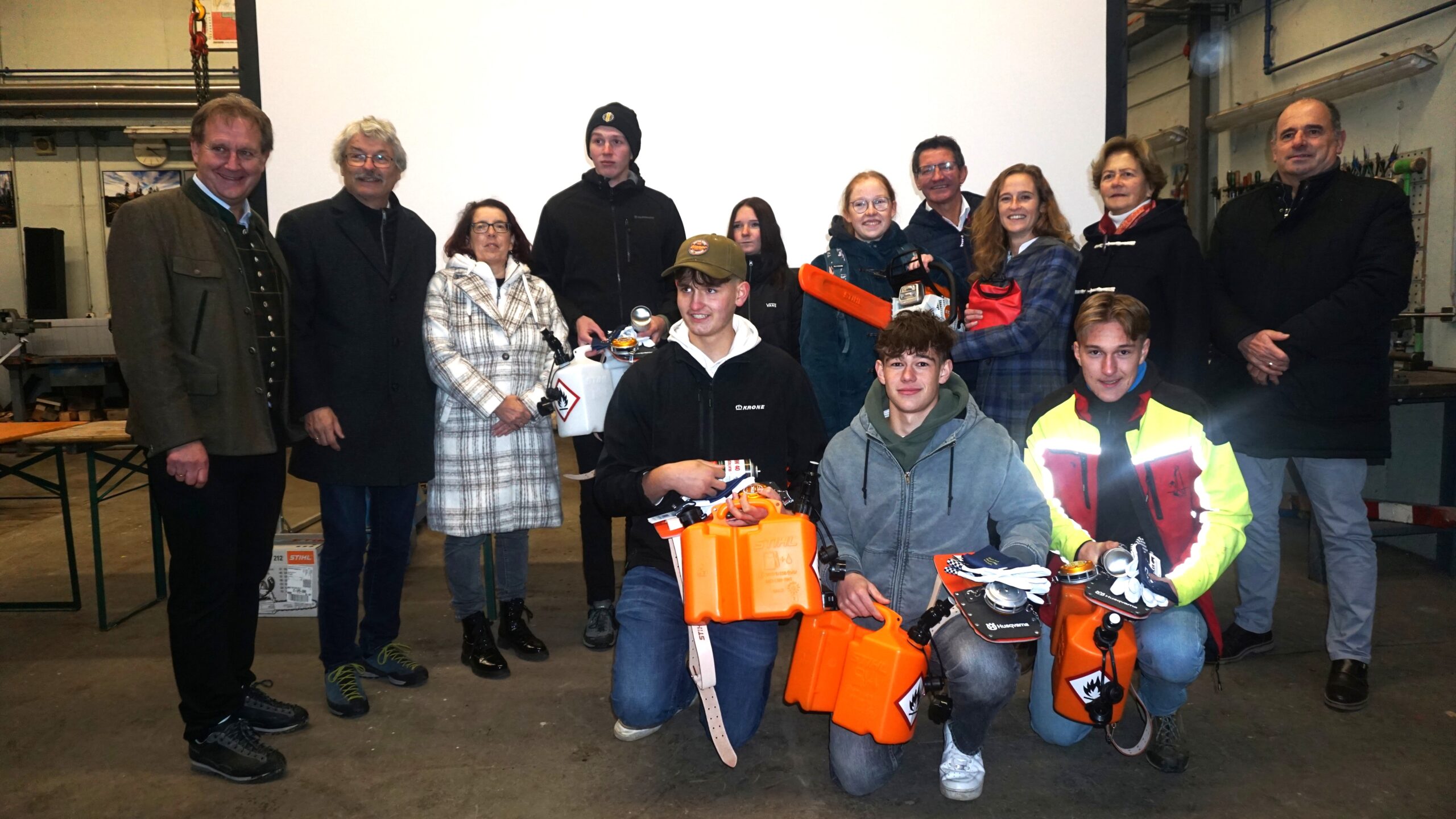 Es stehen mehrere Personen aufgereiht und die Jungs und Mädls in der Mitte halten Preise.